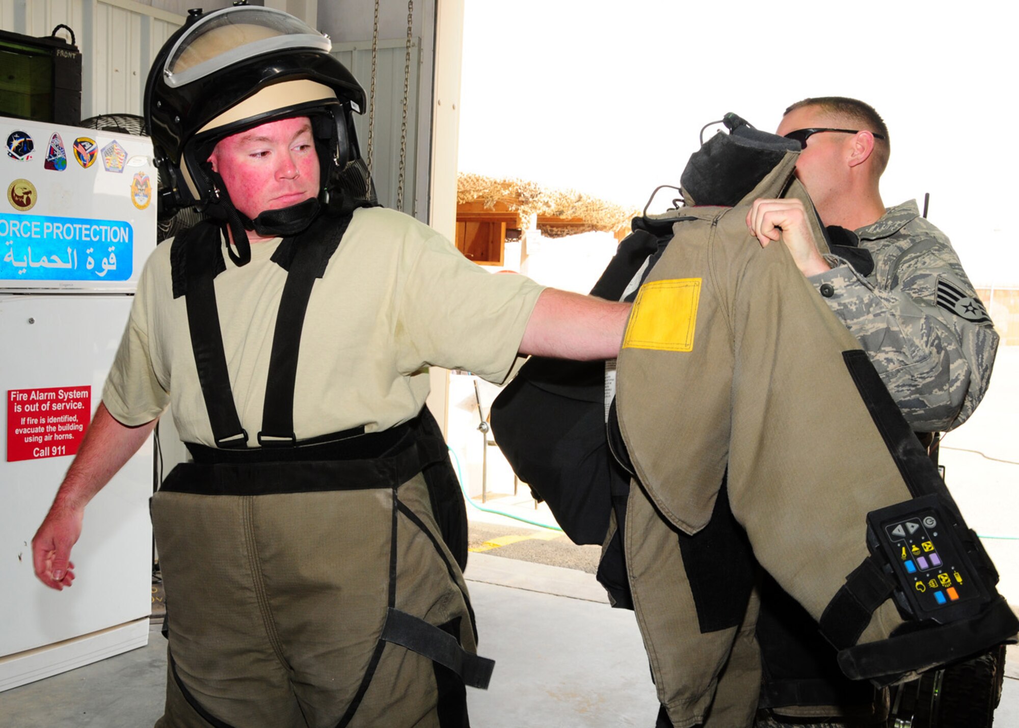 SOUTHWEST ASIA -- Tech. Sgt. Michael O'Toole, 386th Expeditionary Civil Engineer Squadron explosive ordnance disposal, receives assistance with the donning of the Explosive Ordnance Disposal 9 bomb suit during training at an air base in Southwest Asia, May 27. The EOD 9 bomb suit weighs roughly 75 pounds and provides protection from fragmentation, blast and thermal damage. Sergeant O'Toole is deployed from Luke Air Force Base, Ariz., and is originally from East Durham, N.Y. (U.S. Air Force photo/ Senior Airman Courtney Richardson)