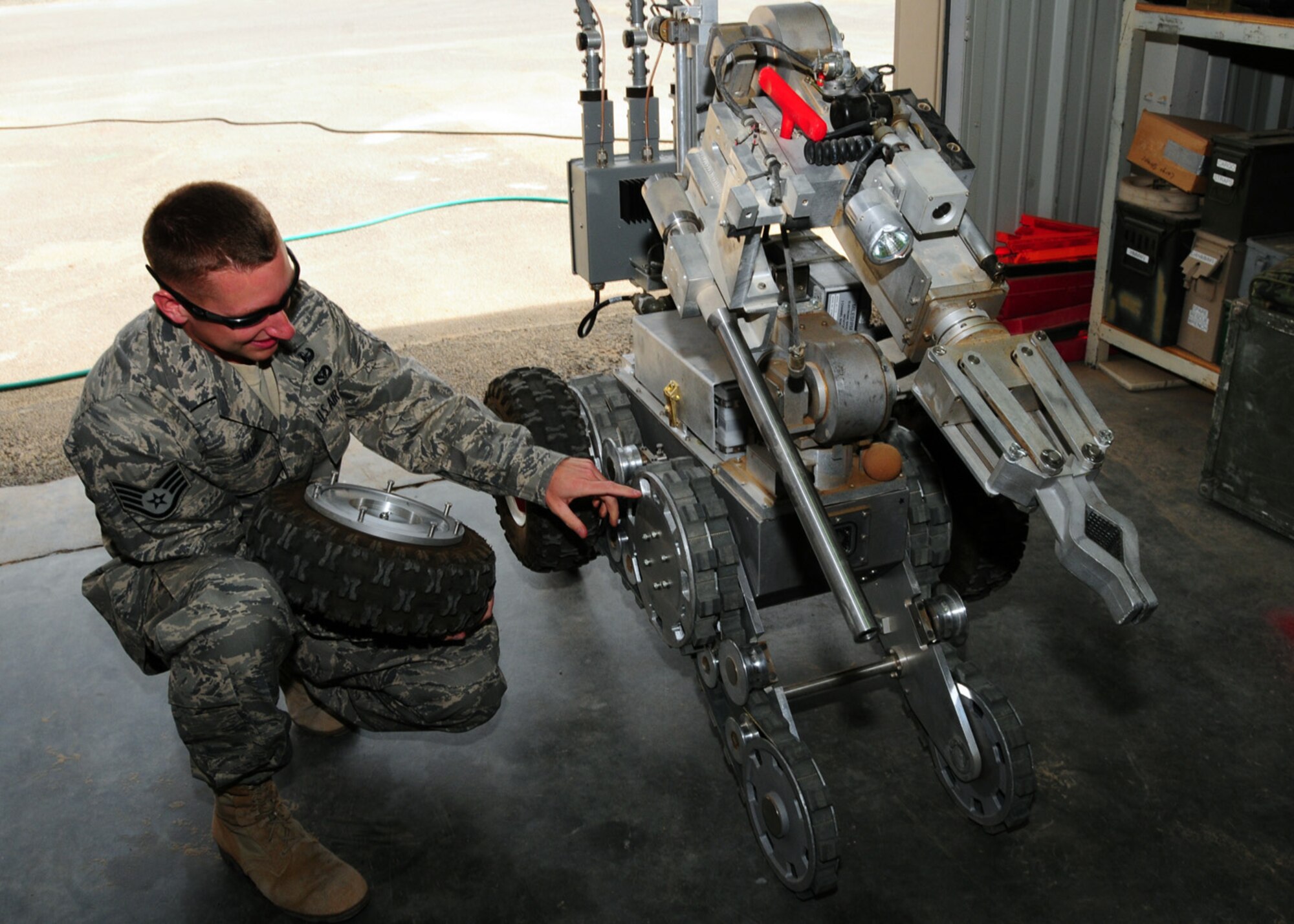 SOUTHWEST ASIA -- Staff Sgt. Brian Dube, 386th Expeditionary Civil Engineer Squadron explosive ordnance disposal, removes a tire from a Remotec ANDROS F6A to ensure the hubs are clean, nothing is binding and the track tension is not too loose at an air base in Southwest Asia, May 27. The robot, used in assistance with unexploded ordnance, is inspected weekly and after each use to ensure its operational and ready at a moment's notice for emergency responses. Sergeant Dube is deployed from Nellis Air Force Base, Nev., and is originally from Torrington, Conn. (U.S. Air Force photo/ Senior Airman Courtney Richardson)