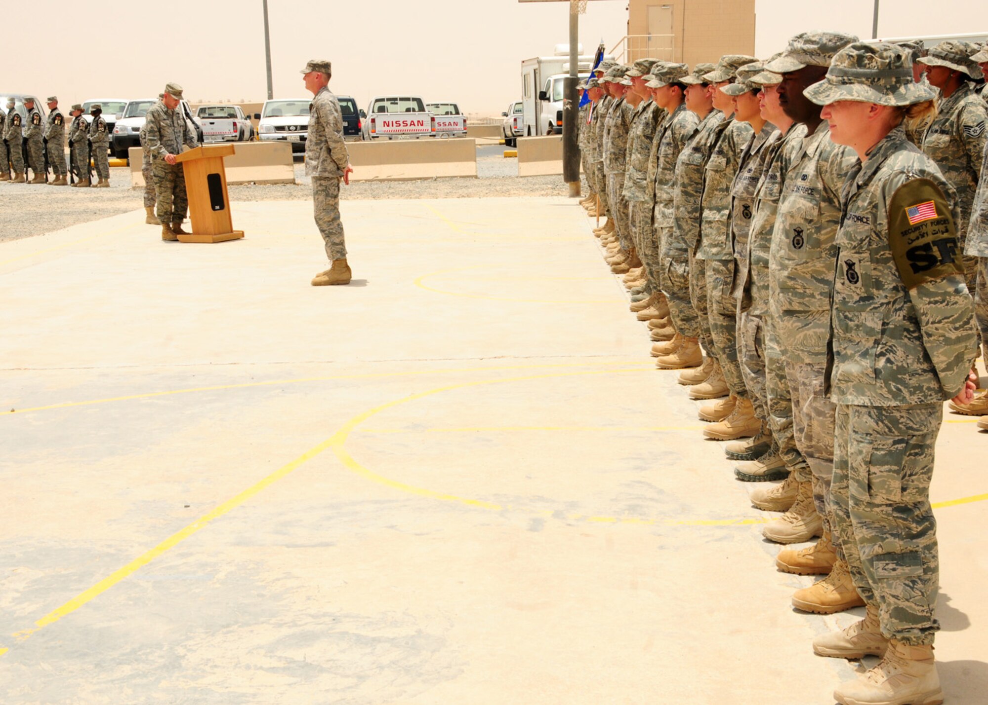SOUTHWEST ASIA -- Airmen from the 386th Air Expeditionary Wing stand at parade rest while listening to an address from Col. Cameron Torrens, 386th AEW commander, during the Memorial Day ceremony at an air base in Southwest Asia, May 25. During the ceremony Taps was played by bugle, the base Honor Guard performed a 21 gun salute and the flag was raised from half-staff to full-staff. Colonel Torrens is originally from Montesano, Wash. (U.S. Air Force photo/ Senior Airman Courtney Richardson)