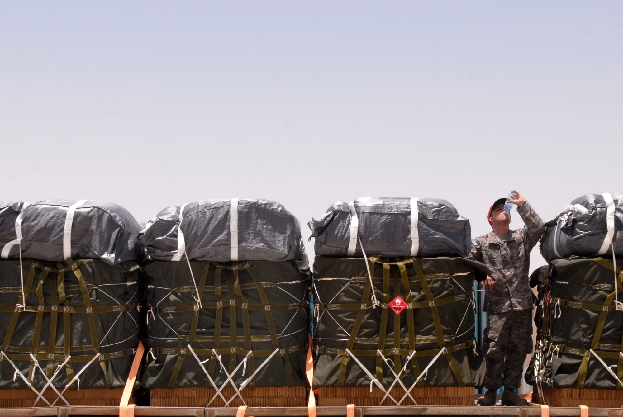 U.S. Army Sergeant Josh Sheptock, a 824th Quartermaster Det 7 Rigger, takes a break to hydrate in the 120 degree heat after loading bundles of JP-8 fuel and gasoline onto a trailer, May 27, 2009 at an undisclosed location in Southwest Asia.  The fuel drums are specially packed by the riggers for the drop from a C-17 Globemaster III to forward operating locations in the U.S. Central Command's Area of Responsibility.  Sergeant Sheptock hails from Fayetteville, N.C. and is deployed from Fort Bragg, N.C., in support of Operations Iraqi and Enduring Freedom and Combined Joint Task Force - Horn of Africa.  (U.S. Air Force photo/Senior Airman Andrew Satran/released)   