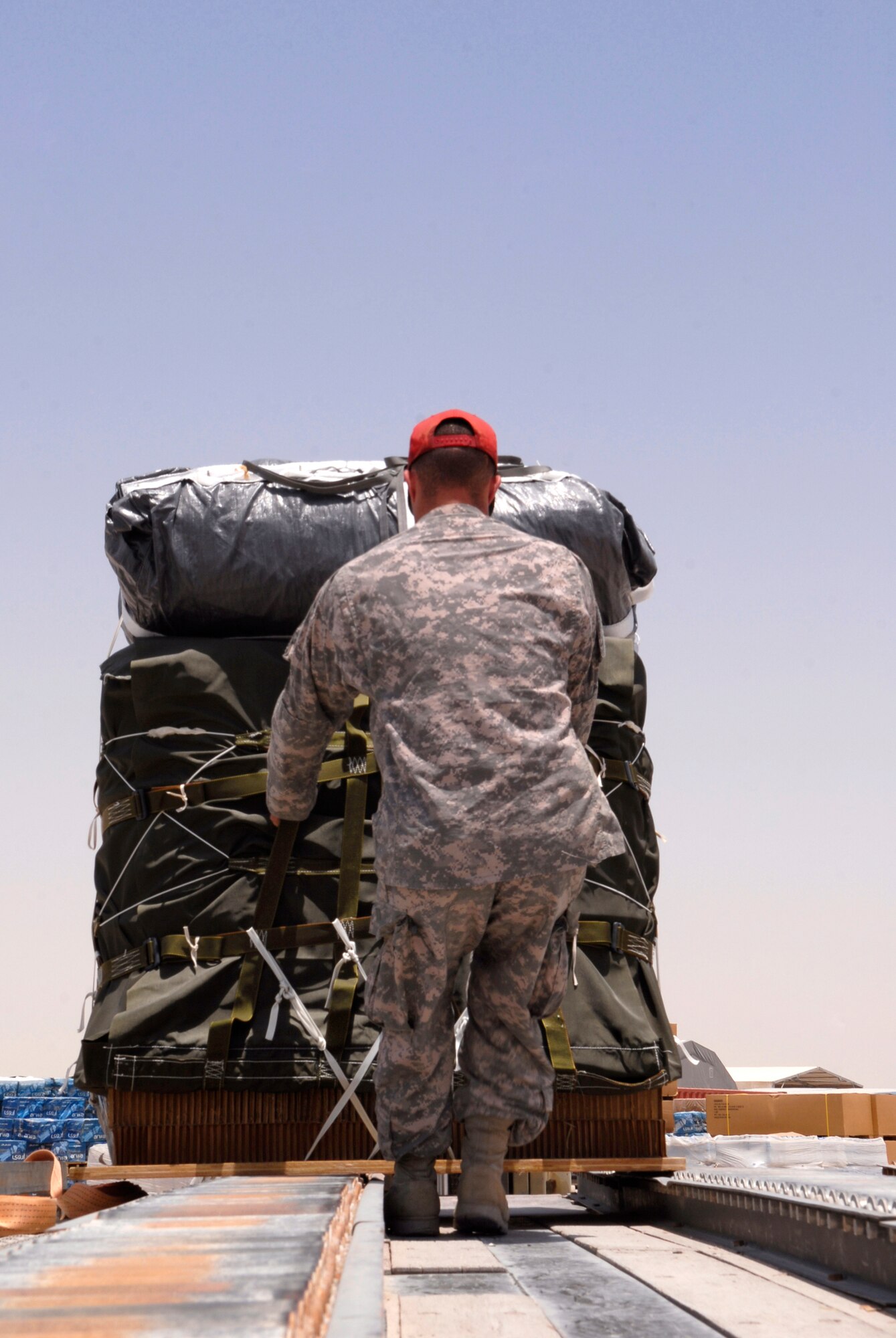 U.S. Army Sergeant Josh Sheptock, an 824th Quartermaster Det 7 Rigger, loads a bundle of JP-8 fuel and gasoline onto a trailer, May 27, 2009 at an undisclosed location in Southwest Asia.  The fuel drums are specially packed by the riggers for the drop from a C-17 Globemaster III to forward operating locations in the U.S. Central Command's Area of Responsibility.  Sergeant Sheptock hails from Fayetteville, N.C. and is deployed from Fort Bragg, N.C., in support of Operations Iraqi and Enduring Freedom and Combined Joint Task Force - Horn of Africa.  (U.S. Air Force photo/Senior Airman Andrew Satran/released)   
