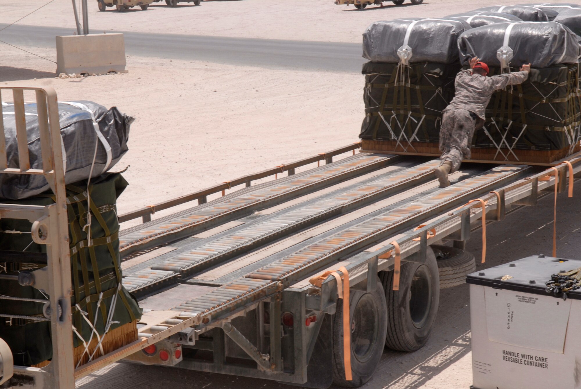 U.S. Army Sergeant Josh Sheptock, an 824th Quartermaster Det 7 Rigger, loads bundles of JP-8 fuel and gasoline onto a trailer, May 27, 2009, at an undisclosed location in Southwest Asia.  The fuel drums are specially packed by the riggers for the drop from a C-17 Globemaster III to forward operating locations in the U.S. Central Command's Area of Responsibility.  Sergeant Sheptock hails from Fayetteville, N.C. and is deployed from Fort Bragg, N.C., in support of Operations Iraqi and Enduring Freedom and Combined Joint Task Force - Horn of Africa.  (U.S. Air Force photo/Senior Airman Andrew Satran/released)   