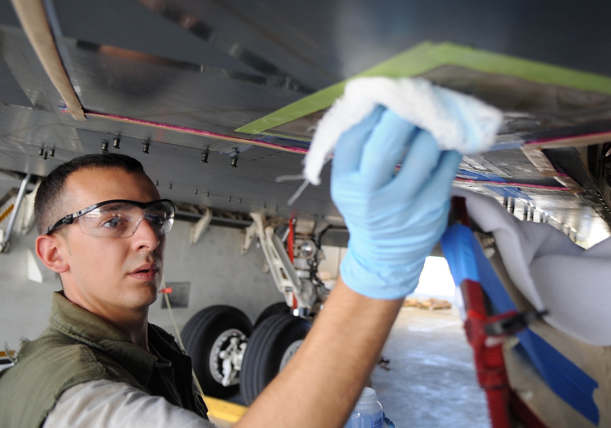 ANDERSEN AIR FORCE BASE, Guam -- Airman Jacob A. Stanley, 509th Expeditionary Aircraft Maintenance Unit low observables technician, prepares the surface of a B-2 Spirit before adhering conductor tape.  The Milwaukee, Wis., native is deployed here from Whiteman AFB, Mo.  (U.S. Air Force photo by Senior Airman Christopher Bush)