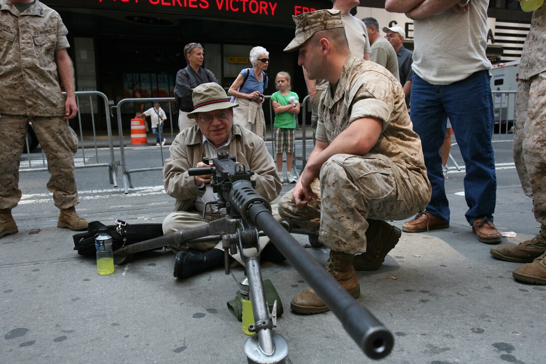 U.S. Marines show an M2 .50 caliber machine gun to a visitor during Marine Day in Times Square, New York, May 23, 2009. The weapon is most commonly used as a turret gun for Humvees and can be mounted on some of the Marine Corps helicopters. The Marines are assigned to the Special Purpose Marine Air Ground Task Force New York.