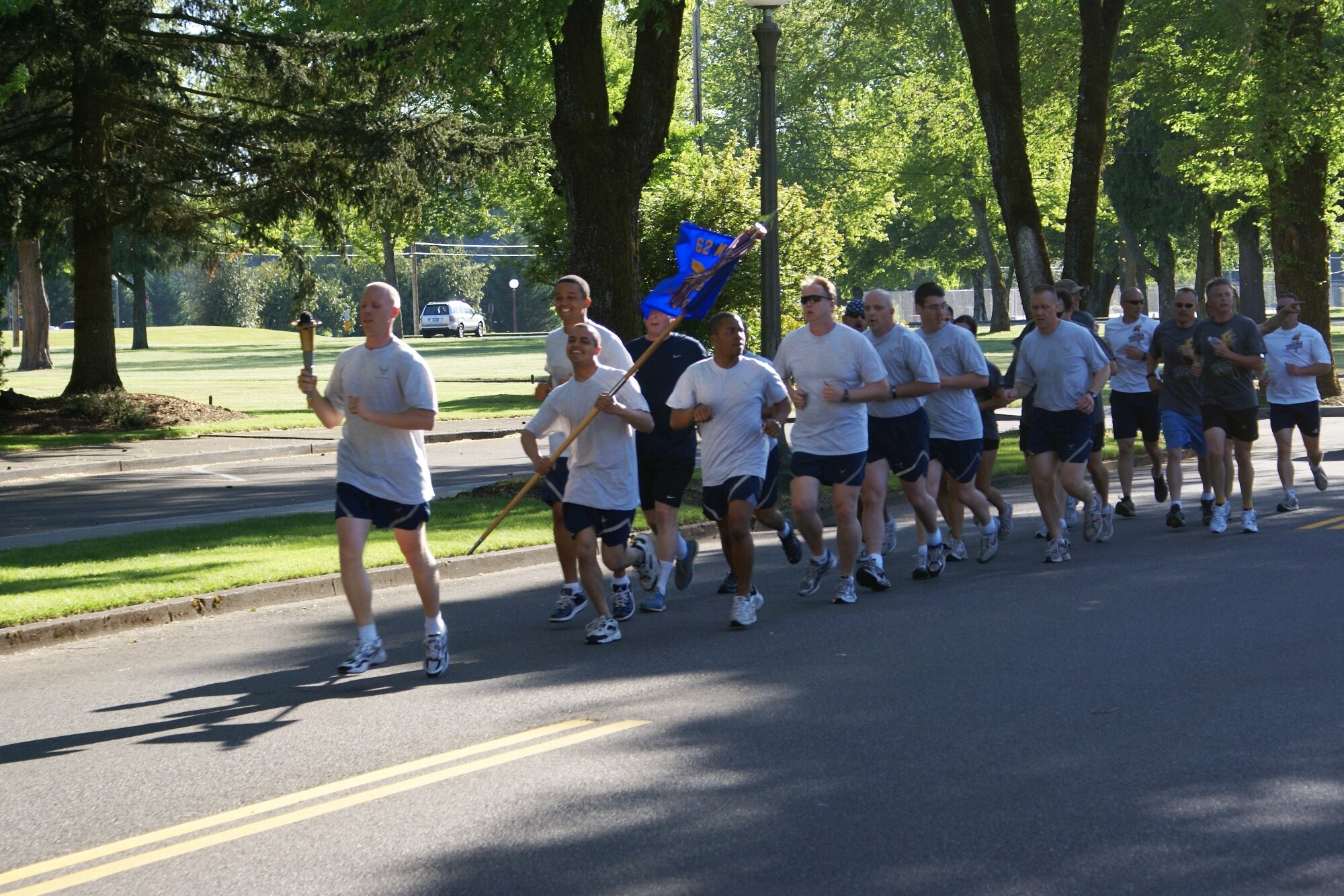 62nd Security Forces Squadron members and Washington law enforcement officers participate in the annual Law Enforcement Special Olympics Torch Run here May 29. The “Flame of Hope” arrived at McChord for the opening ceremonies of the Special Olympics Washington Summer Games. McChord and Fort Lewis are teamed up to host more than 8,000 athletes, coaches and volunteers participating in the annual Summer Games. Events occur on McChord and Fort Lewis including aquatics, athletics (field events), cycling, power lifting, and soccer are part of this year's competition. (U.S. Air Force photo/Staff Sgt. Eric Burks)