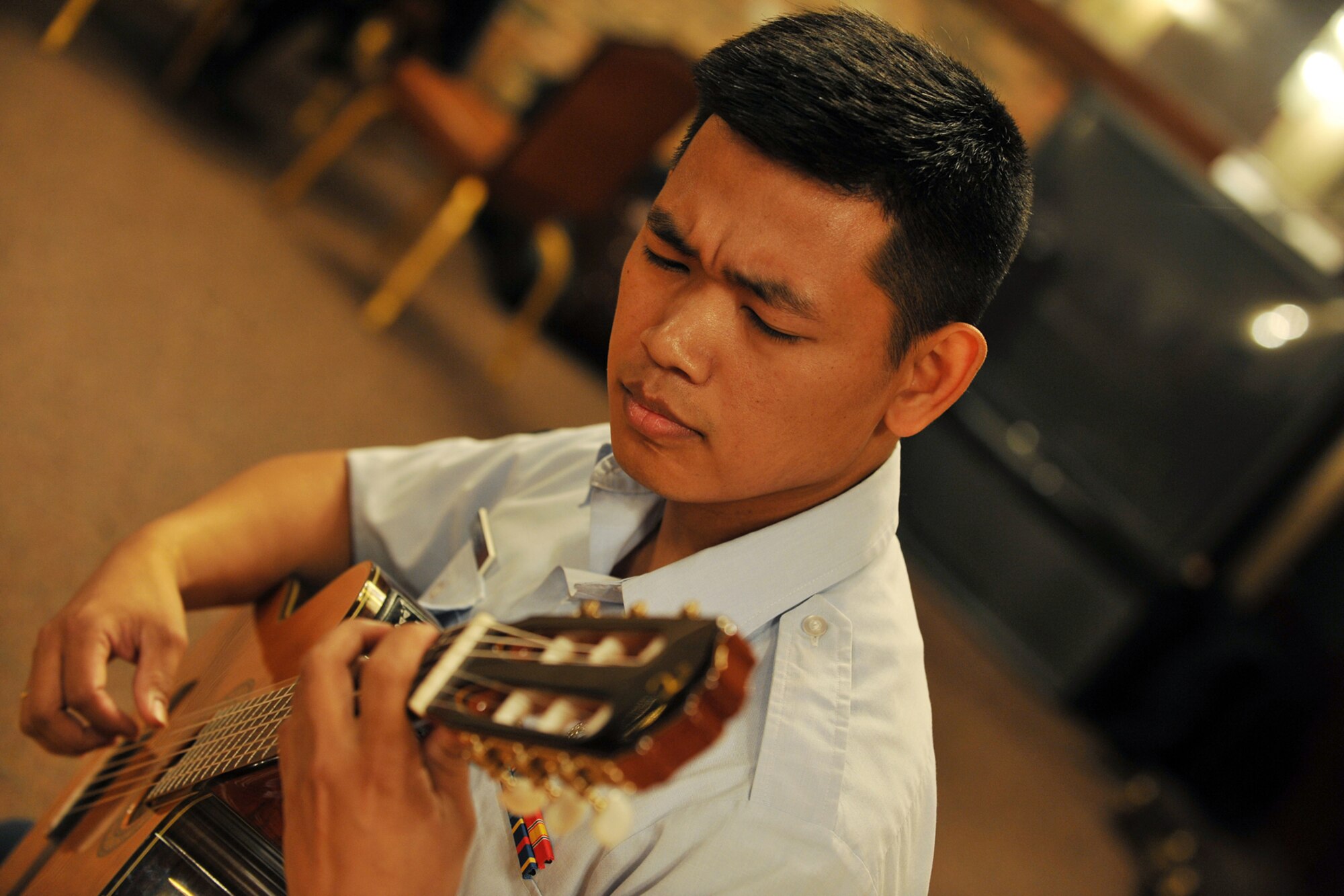 OFFUTT AIR FORCE BASE, Neb., -- Senior Airman Daniel Santos, a classical guitarist with the Heartland of America Band, plays the guitar during the first concert of the Lunch Bachs concert series at the Community Activity Center here May 28. The concert series consists of four 45-minute concerts U.S. Air Force photo by Charles Haymond 