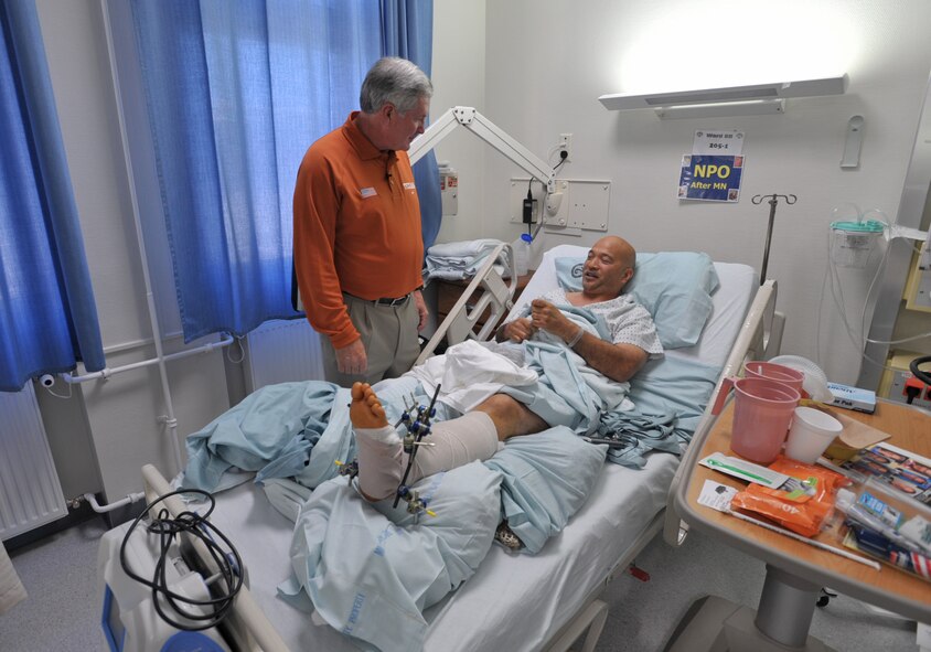 Mack Brown, head football coach at Texas University, visits with Henry Bautista at a U.S. military hospital in Landstuhl, Germany. The hospital was one of the first stops for Coaches Tour 2009, a morale-boosting mission that brings NCAA football coaches to U.S. servicemembers and their families. Bautista served 10 years in Army intelligence without any major injuries before he became a civilian field representative for an armored vehicle contractor. He was flown to Germany from Iraq after his leg was severely injured by a mishap with one of the vehicles. The Coaches Tour is organized by Morale Entertainment, LLC., in association with Armed Forces Entertainment. (U.S. Air Force photo/Tech. Sgt. Jason Schaap)