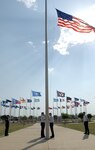 A Retreat team lowers the flag during a ceremony at the Lackland parade grounds May 15. The Retreat ceremony marked the end of National Police Week. Ceremonies and activities throughout the week honored federal, state and municipal officers in recognition of their service. (U.S. Air Force photo/Alan Boedeker)                               
