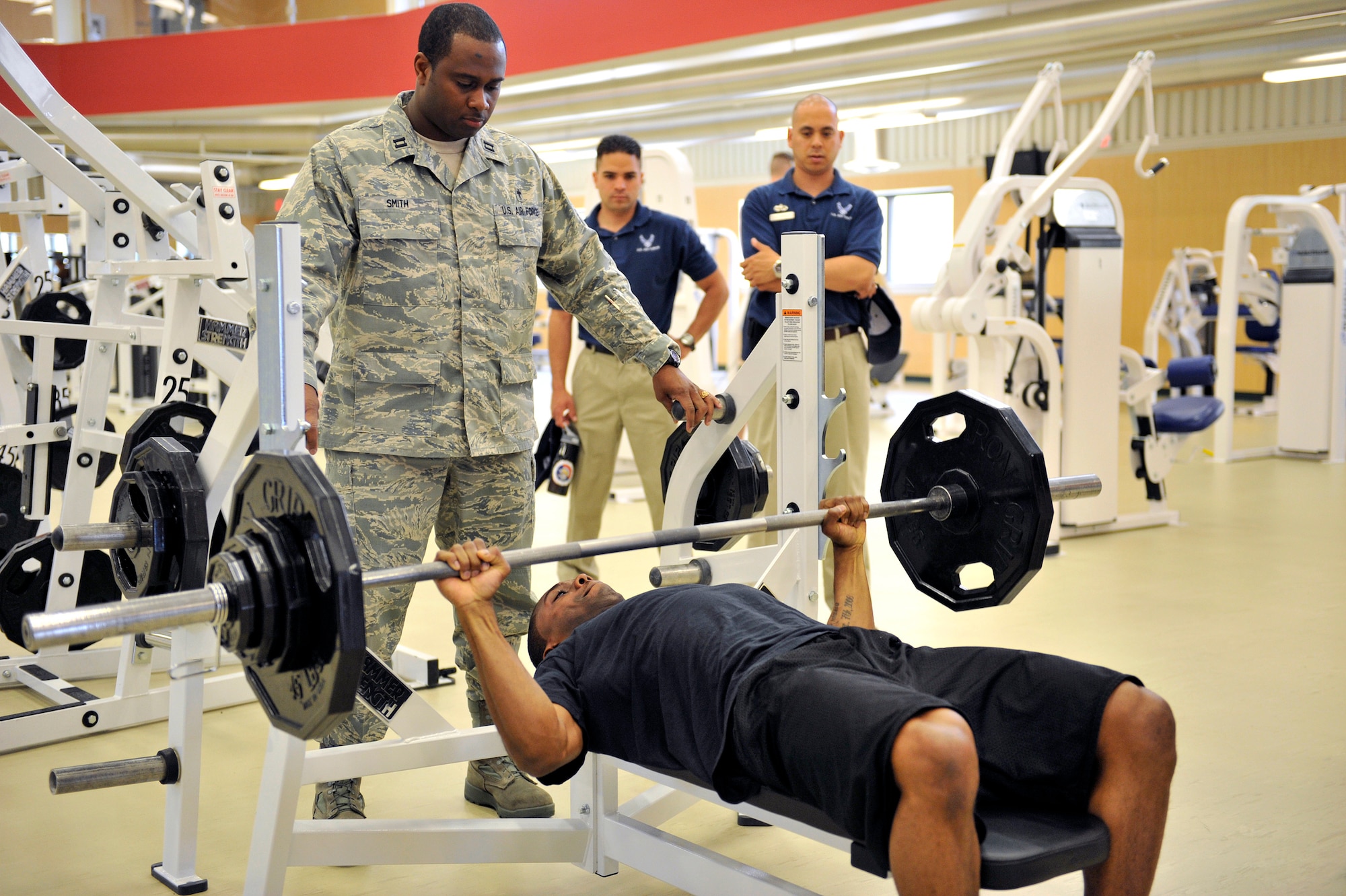 Chaplain (Capt.) Corwin Smith, 341st Missile Wing chaplain, spots while Staff Sgt. Emmanuel Booth, 341st MW chaplain's assistant, competes in a bench press competition May 27 during the new fitness center's grand opening activities.  Sergeant Booth took first place in that event. (U.S. Air Force photo by John Turner)
