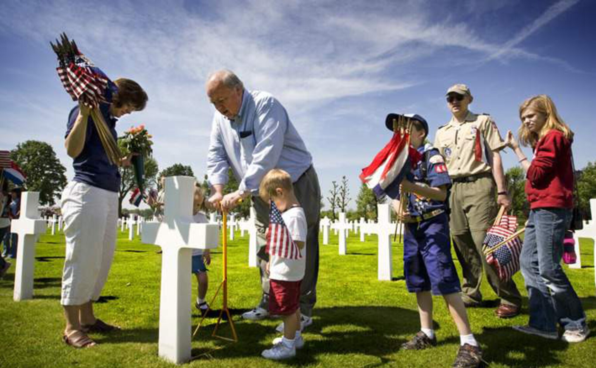MARGRATEN, The Netherlands – Hanna Cornett, daughter of Senior Master Sgt. Roderick Cornett, 701st Munitions Support Squadron, places flags at the graves of fallen service members before a Memorial Day ceremony at the Netherlands American Cemetery and Memorial May 23, 2009. The Netherlands American Cemetery and Memorial is Europe's third largest war cemetery for unidentified soldiers who died in World War II. (Courtesy photo)