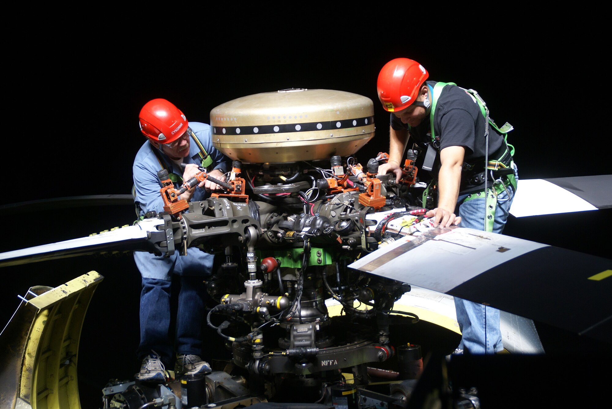 Rick Mcllmoil and Jose Rosario, National Full-Scale Aerodynamics Complex aircraft mechanics, conduct preflight checks of the UH-60 rotor before individual blade control test in the facility's 40 by 80-foot wind tunnel. (Photo by Jeff Johnson)
