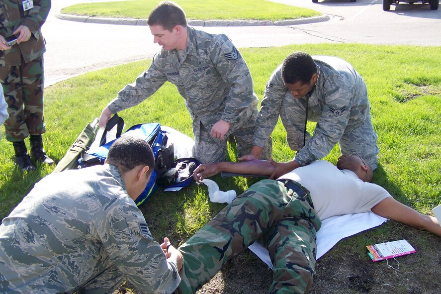 Senior Airman Benjamin Pace (left), Staff Sgt. Christopher Franken and Airman 1st Class Kevin Tucker (right), all of the 319th Medical Operations Squadron, care for their "patient" during a recent 319th Medical Group exercise. The exercise was designed to test medical personnel on their first response to multiple casualties. (U.S. Air Force photo/Senior Airman Jennifer Ferrizzi)

