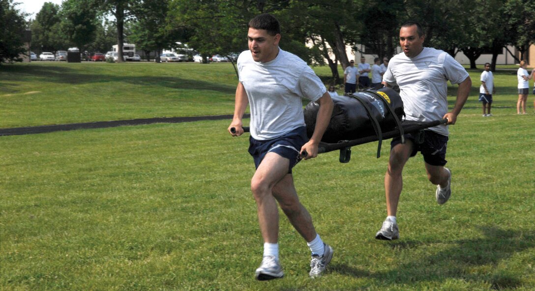 William Bauer, left, and Andrew Rivera, right, 316th Logistics Readiness Squadron, carry a litter during Wing Sports Day. (U.S. Air Force photo/ Staff Sgt. Melissa Stonecipher)