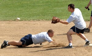 Dwight Veon, 316th Security Forces Squadron, slides toward Kurt Skarstedt, 1st Helicopter Squadron, as he prepares to catch an incoming ball at the softball field across from the West Fitness Center. (U.S. Air Force photo/ Senior Airman Giang Nguyen)