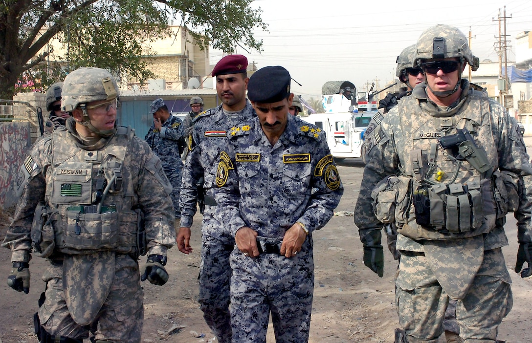 U.S. Army Lt. Col. Louis Zeisman along with Iraqi Brig. Gen. Ali Ibraheem Dabown  and Col. Timothy McGuire walk down a neighborhood street in the city of Sumer Al-Ghadier,  in the 9 Nissan district of eastern Baghdad, May 28, 2009. Dabown commands the  Iraq's 2nd National Police Division's 8th Brigade. Zeisman commands the 82nd Airborne Division's 3rd Brigade Combat Team, Multinational Division Baghdad. 