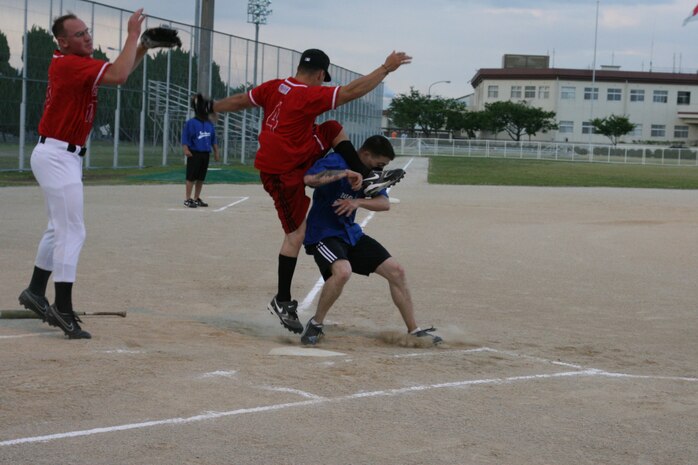 A Dragons player collides with Swingn Styx third baseman Charles Cruz while he outruns an over thrown ball to the plate. Both Cruz and catcher Joshua Ropchock could not jump high enough to bring down the ball to get::r::::n::the out.