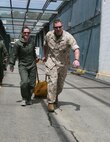 1st Lt. James Arrasmith, commanding officer, A Company, Chemical Biological Incident Response Force, II Marine Expeditionary Force, helps a spouse drag a simulated casualty on a SKED [stretcher] at Jane Wayne Day here, May 29.