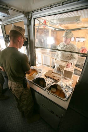 Lance Cpl. Alexander Angelikas, a food service specialist with Combat Logistics Battalion 4, 2nd Marine Logistics Group (Forward), prepares a sandwich for a Marine with Company A, 1st Battalion, 7th Marine Regiment, at Contingency Outpost Viking, Iraq, May 30, 2009. The six Marines from CLB-4 are able to cook one to three hot meals a day for the Marines and sailors aboard COP Viking. (U.S. Marine Corps photograph by Cpl. Robert S. Morgan)