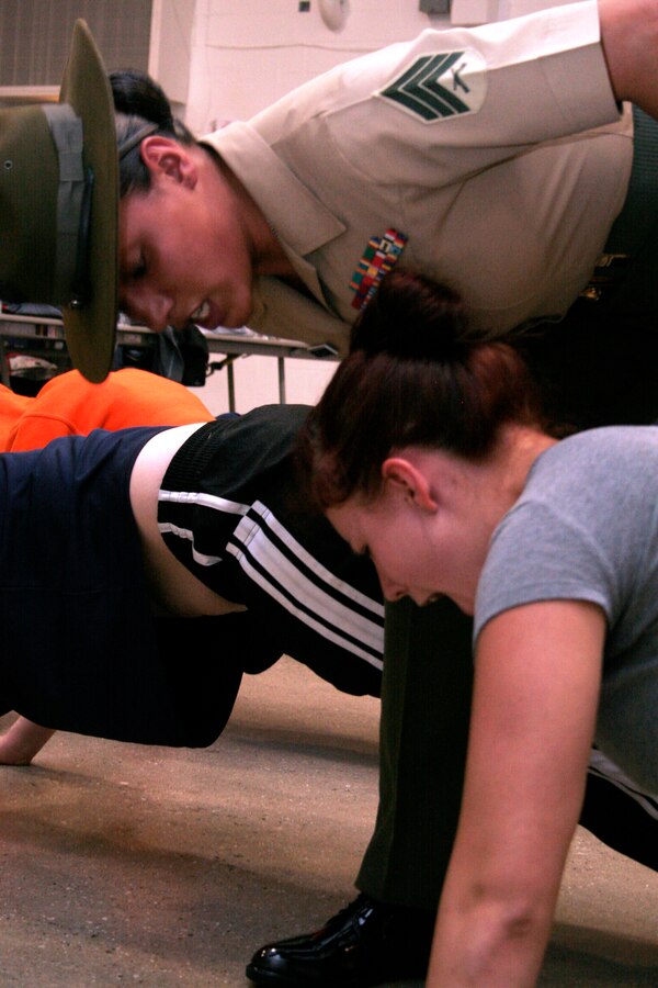 Drill Instructor Sgt. Maria Arellano corrects Kylie Scurto during a female pool function March 30 at the U.S. Marine Corps Reserve Center in Madison, Wis. Recruiting Station Milwaukee recruiters hope a new focus on female-only-functions will lower its female pool attrition rate, which is currently at 26 percent. Arellano is a drill instructor at Marine Corps Recruit Depot Parris Island, S.C. and Scurto is a poolee at Recruiting Substation Rockford, Ill.