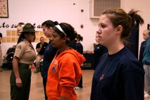 Paige Draheim (right) maintains her position of attention while Drill Instructor Sgt. Maria Arellano corrects another poolee during a female pool function March 30 at the U.S. Marine Corps Reserve Center in Madison, Wis. Recruiting Station Milwaukee recruiters hope a new focus on female-only functions will lower its female pool attrition rate, which is currently at 26 percent. Draheim is a poolee at Recruiting Substation Rockford, Ill., and Arellano is a drill instructor at Marine Corps Recruit Depot Parris Island, S.C.