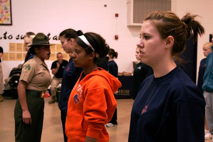 Paige Draheim (right) maintains her position of attention while Drill Instructor Sgt. Maria Arellano corrects another poolee during a female pool function March 30 at the U.S. Marine Corps Reserve Center in Madison, Wis. Recruiting Station Milwaukee recruiters hope a new focus on female-only functions will lower its female pool attrition rate, which is currently at 26 percent. Draheim is a poolee at Recruiting Substation Rockford, Ill., and Arellano is a drill instructor at Marine Corps Recruit Depot Parris Island, S.C.