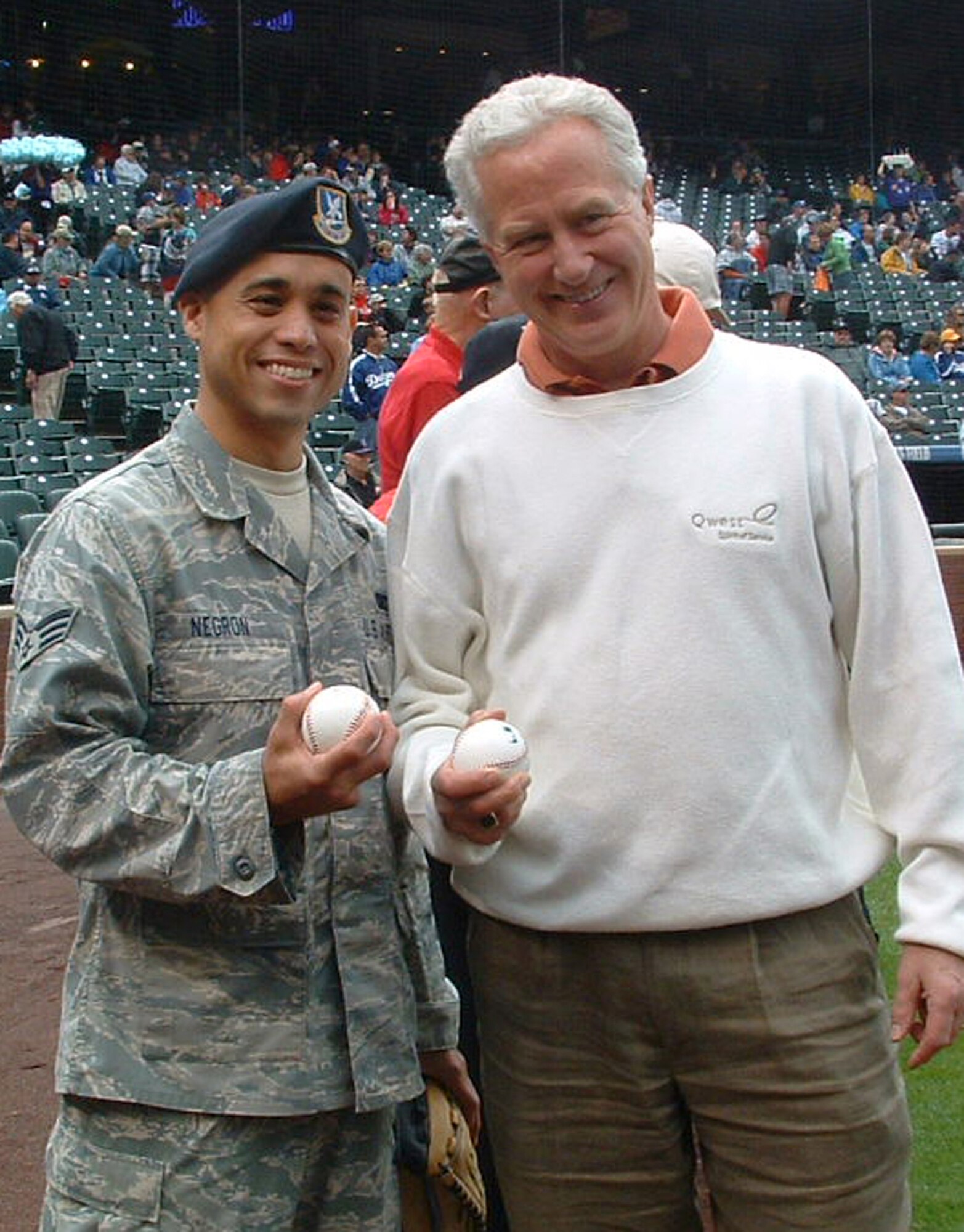 Senior Airman Miguel Negron, a member of the Air Force Reserve's 302nd Security Forces Squadron, stops for a photo with another honorary pitcher May 25 at Coors Field in Denver. Airman Negron was selected to throw out the first pitch in front of more than 37,000 fans of Denver's Colorado Rockies during their Memorial Day 2009 game against the Los Angeles Dodgers. Airman Negron was joined by Staff Sgt. Frances Kness, a vocalist with the AF Reserve Command band, who sang both the National Anthem and God Bless America for the thousands in attendance. Airman Negron and the 302nd SFS are based at Peterson Air Force Base, Colo. (U.S. Air Force photo/Maj. Kallece Quinn)