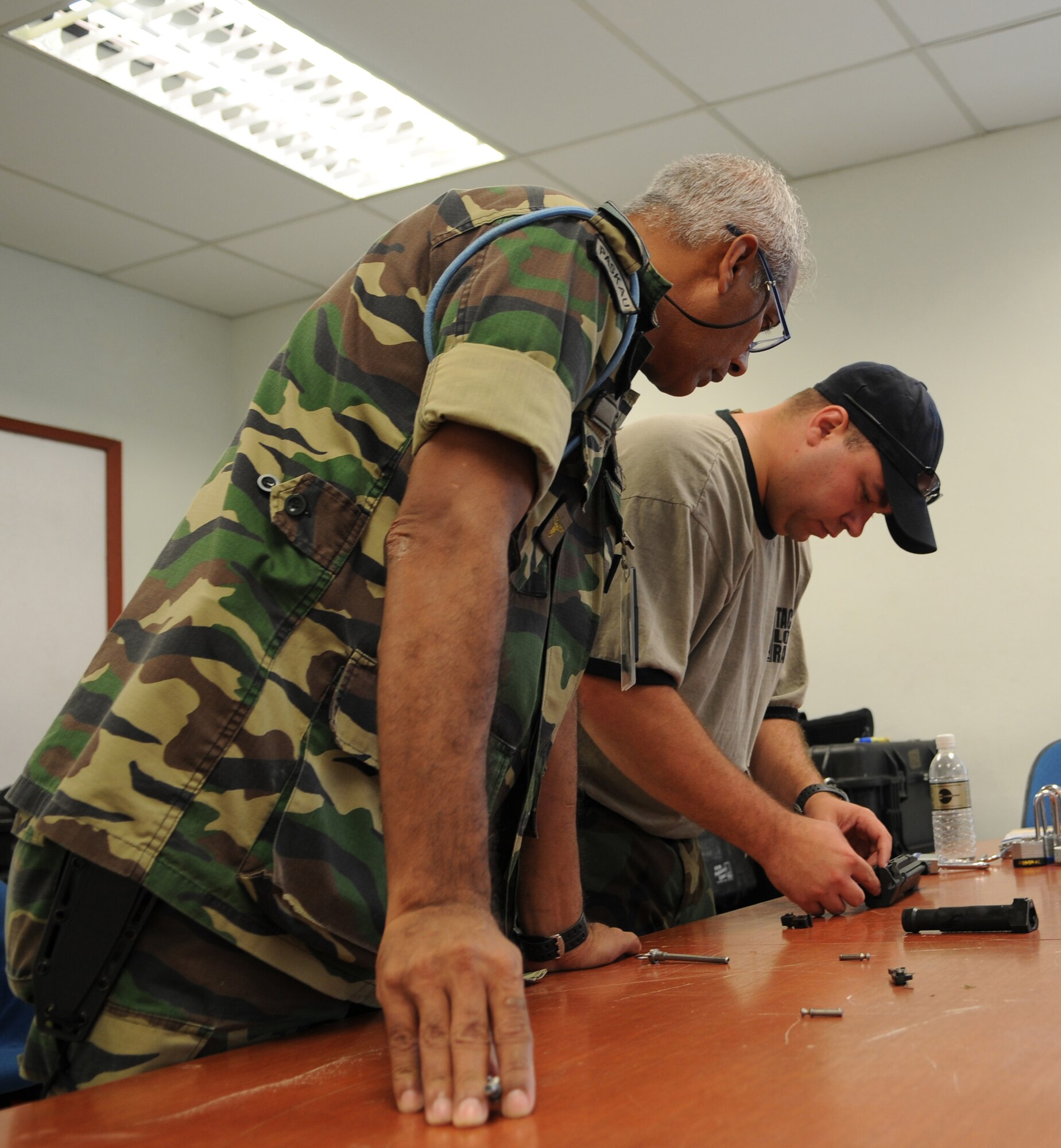 ON A MILTARY INSTALLATION IN MALAYSIA -- Tech. Sgt. Will Sanderson, a weapons specialist with the 320th Special Tactics Squadron, shows a Paskua member how to do reassemble a bolt assembly for a M107 .50 caliber sniper rifle during a tactical long range shooting course here May 28 as part of Teak Mint 09-1. Weapons specialists from the 320th STS taught members of 320th and Paskau, the special operations branch of the Royal Malaysian Air Force, during the two-day course. Teak Mint 09-1 is a training exchange designed to enhance U.S and Malaysian military training and capabilities. (Photo by Tech. Sgt. Aaron Cram)