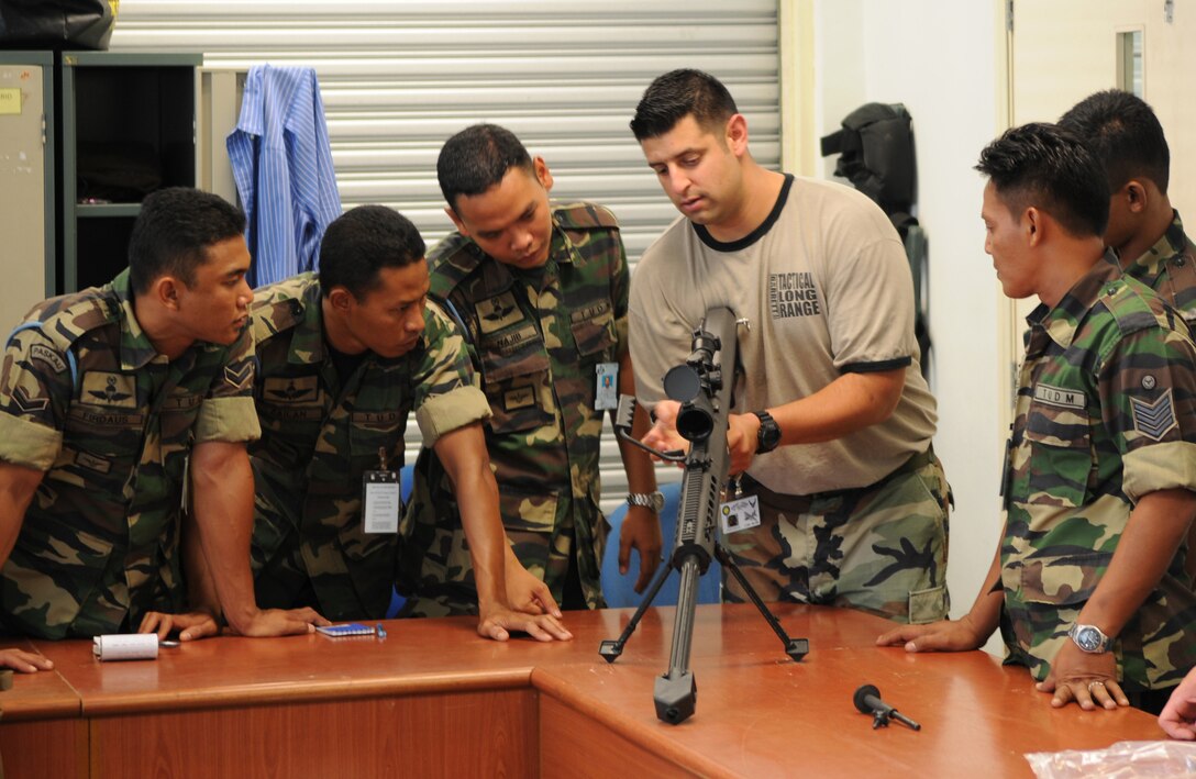 ON A MILTARY INSTALLATION IN MALAYSIA -- Staff Sgt. Jay Gonzales, a weapons specialist with the 320th Special Tactics Squadron, Paskua members how to do a function check on a M107 .50 caliber sniper rifle during a tactical long range shooting course here May 28 as part of Teak Mint 09-1. Weapons specialists from the 320th STS taught members of 320th and Paskau, the special operations branch of the Royal Malaysian Air Force, during the two-day course. Teak Mint 09-1 is a training exchange designed to enhance U.S and Malaysian military training and capabilities. (Photo by Tech. Sgt. Aaron Cram)