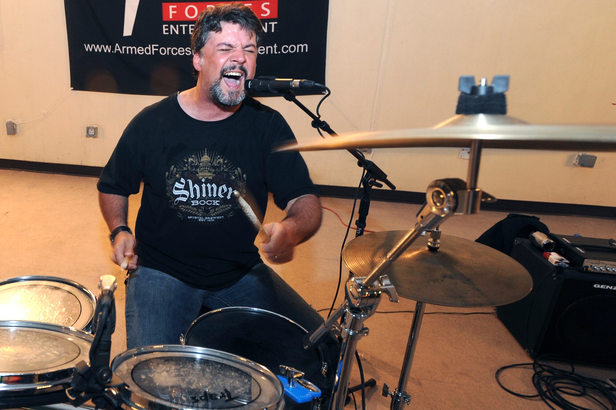 Rob Rennier, handles drums and vocals for the Matt Poss and Rolling Thunder band; here he sings backup during a concert the band put on for servicemembers, May 27, 2009, in an undisclosed location in Southwest Asia.  The band played original music as well as covers of major artists during the Armed Forces Entertainment tour to multiple bases within the U.S. Central Command's area of responsibility.  (U.S. Air Force photo by Staff Sgt. Joshua Garcia/released)