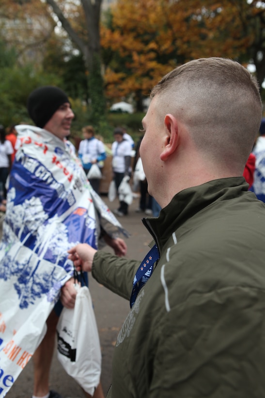 Lance Corporal Brian M. Woodruff hands a bag of water and food to finishers of the 39th Annual New York City Marathon, Nov. 1, 2009. Marines from the Special Purpose Marine Air Ground Task Force 26 cheered and congratulated the runners while passing out refreshments just after the finish line. SPMAGTF-26 was formed to support the commissioning of the USS New York, Nov. 7, 2009. Marines of SPMAGTF-26 represent future Marine Corps expeditionary forces who will deploy on and from a vessel built around the Navy-Marine Corps team.
