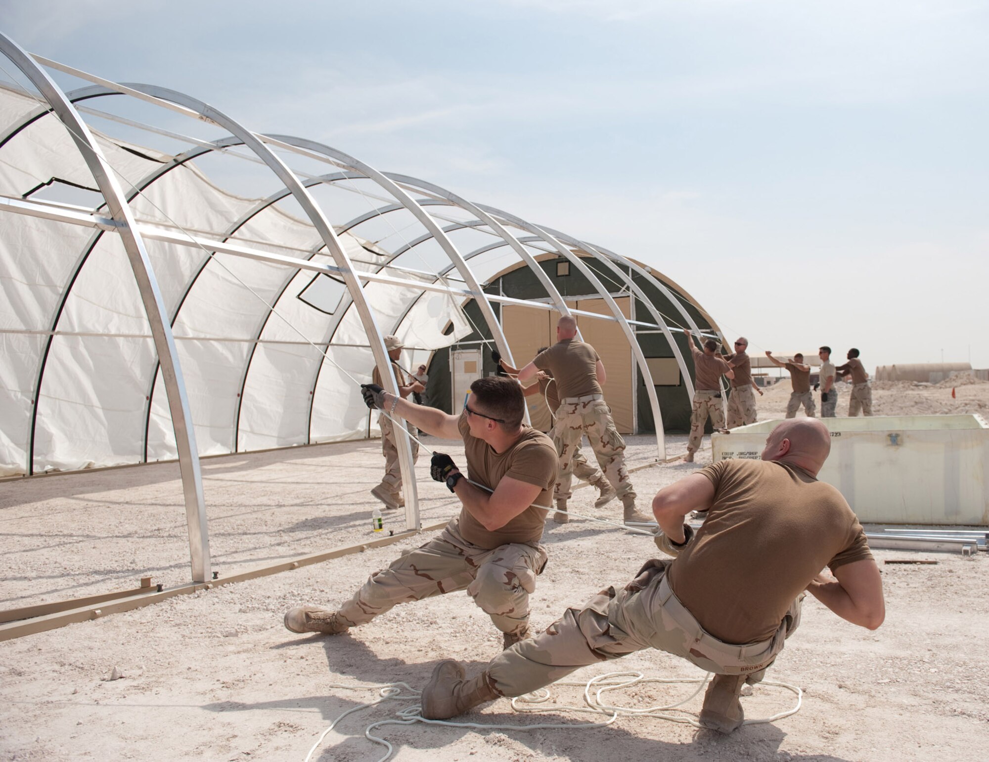 Right, U.S. Navy Aviation Warfare Systems Operator 2 Jake Brown and AWO2 Joey Donaldson pull a rope, guiding the roof of a tent being constructed for Navy maintenance operations, Oct. 23, 2009, in Southwest Asia. The Navy is relocating its maintenance operations from a separate location across base. The VP-10 squadron maintains and operates the P-3 Orion, a land-based, long-range, anti-submarine warfare patrol aircraft that performs regular missions in support of Operation Enduring Freedom.  (U.S. Air Force photo/Staff Sgt. Robert Barney) 