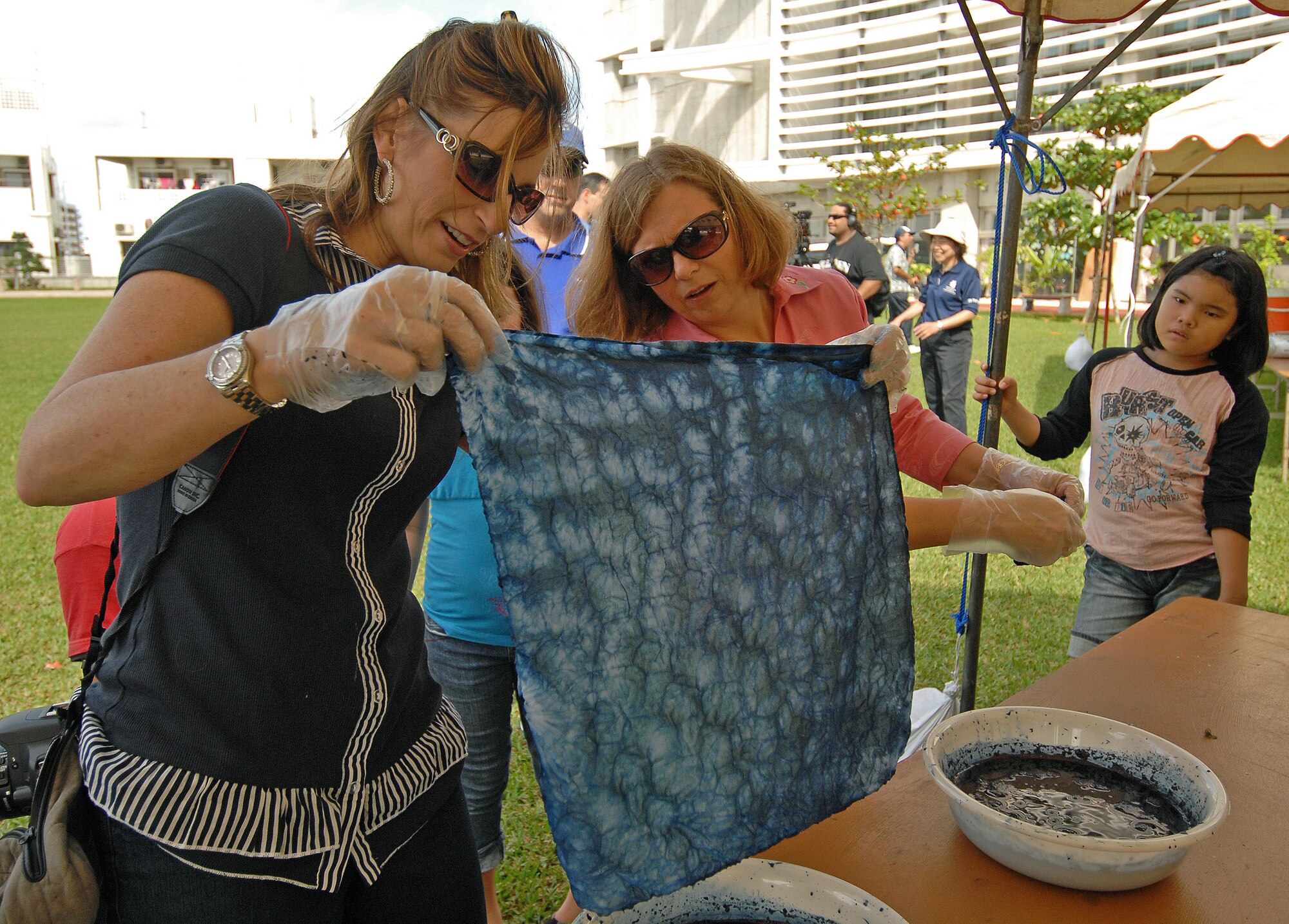 Cindy Wilsbach, wife of 18th Wing Commander Brig. Gen. Kenneth Wilsbach, and Sheri Fletcher, wife of 18th Mission Support Group Commander Col. Kelly Fletcher, check their tie dye designs while participating in a workshop at the Kadena Circle Festival Oct. 31. The two-day festival hosted by Kadena Town brought together hundreds of base and local residents through activities such as tie-dyeing, karate demonstrations, rice pounding, musical performances and a friendly game of children’s dodge ball. (Air Force/Staff Sgt. Jason Lake)