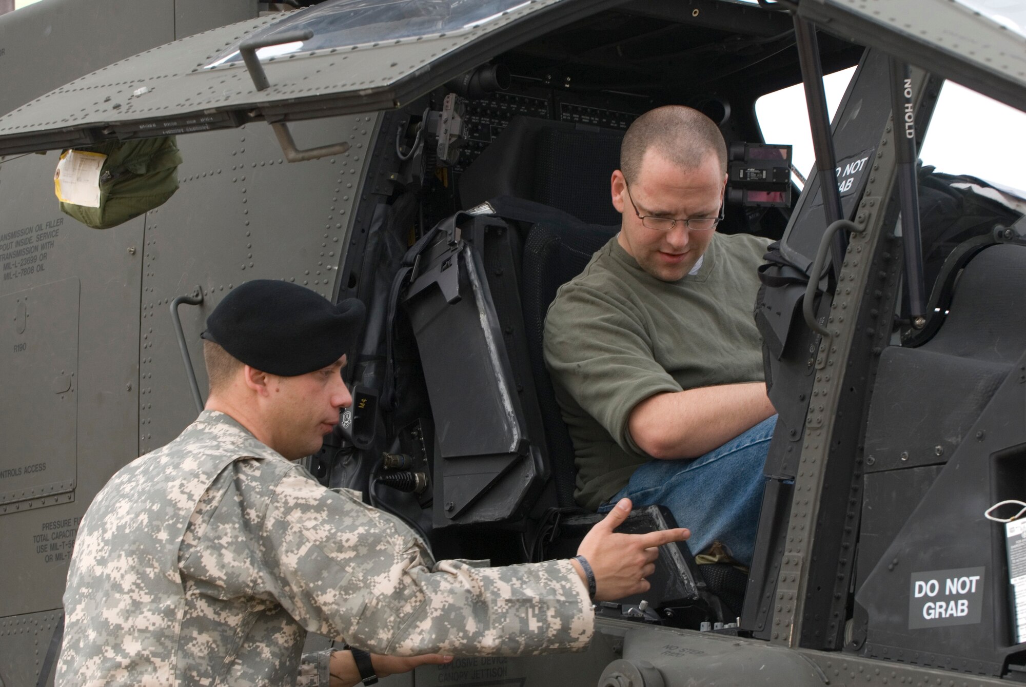KUNSAN AIR BASE, Republic of Korea -- Chief Warrant Officer 2 Dave Bremer, Alpha Company 4-2 Aviation Regiment, gives general information on the AH-64D Apache Longbow Helicopter to Staff Sgt. Milton Jump, 8th Communication Squadron network advisor, during the Gunsan Saemangeum Airshow Oct. 31. Kunsan Air Base opened its doors to more than 900 people to showcase the unique capabilities of the 8th Fighter Wing. (U.S. Air Force photo/Senior Airman Roy Lynch)