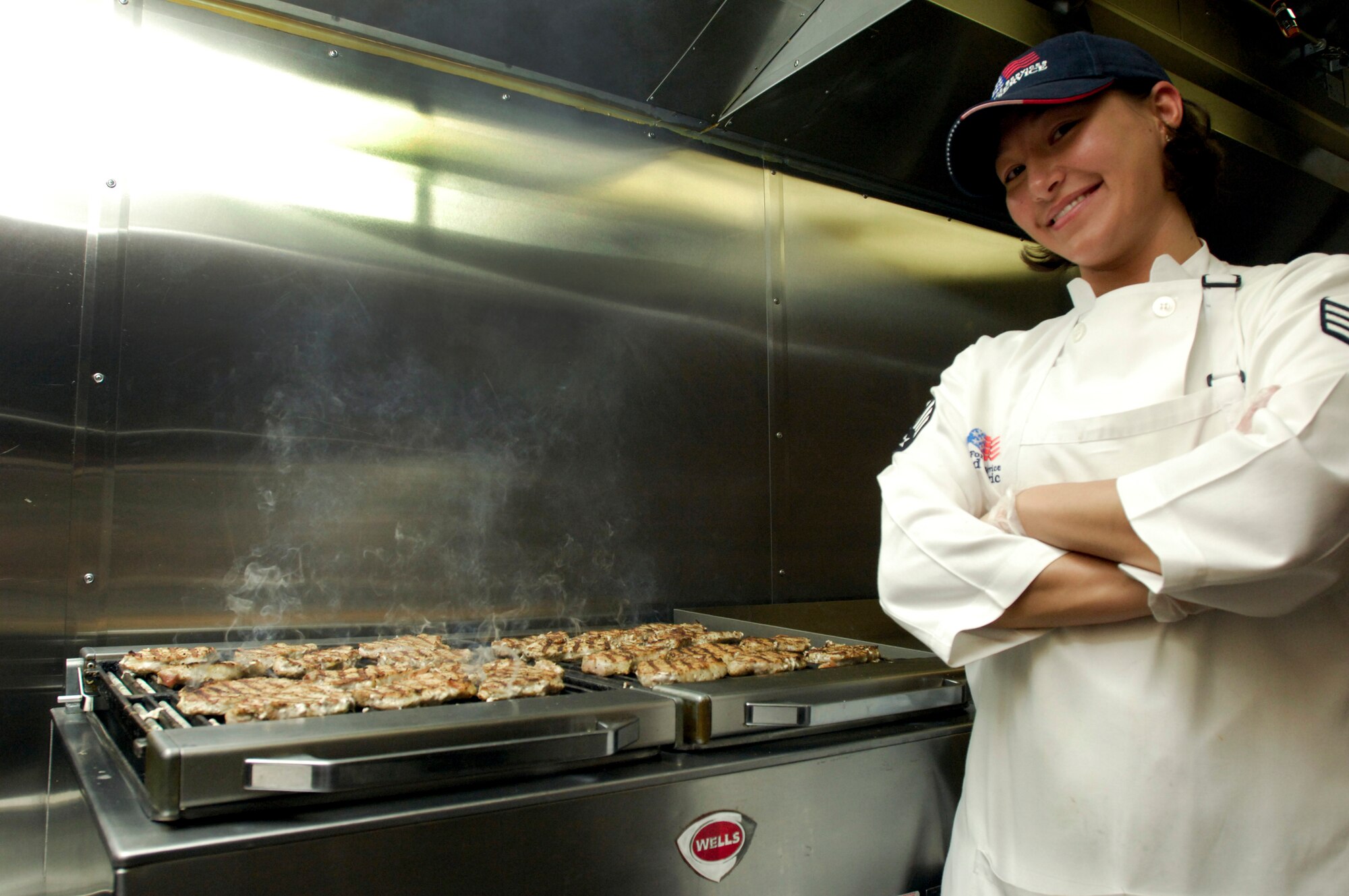 ELMENDORF AIR FORCE BASE, Alaska – Senior Airman Angel Ramirez, 3rd Force Support Squadron food service apprentice, stands in front of the pork chops she prepared Oct. 29 at the Iditarod Dining Hall. Ramirez was selected as one of the 2009 John L. Hennessy award winners earlier this year, which recognizes culinary excellence. (U.S. Air Force photo/Airman 1st Class Christopher Gross)