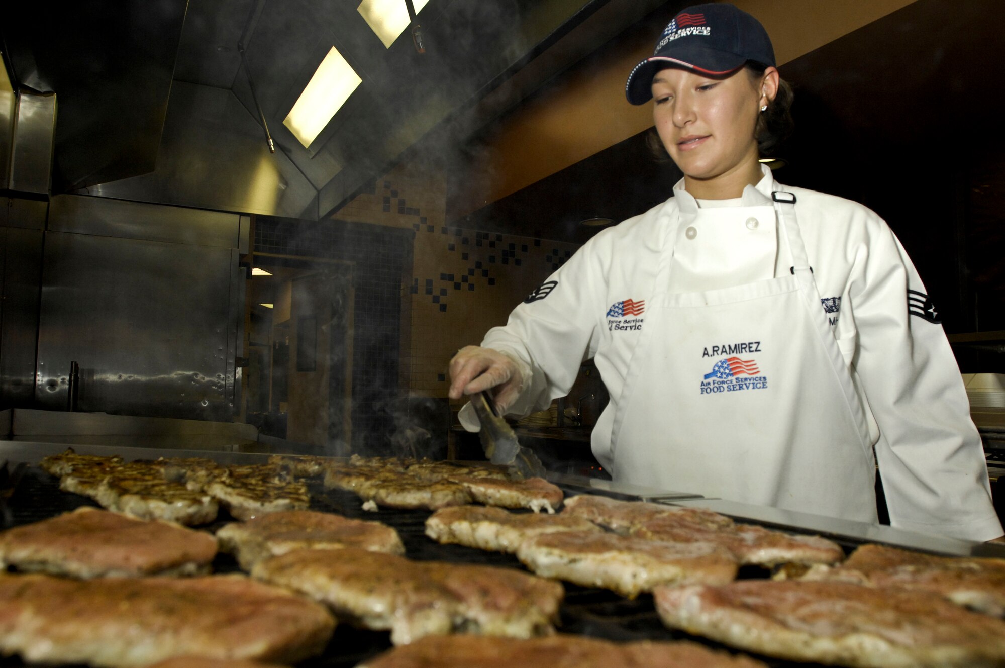 ELMENDORF AIR FORCE BASE, Alaska – Senior Airman Angel Ramirez, 3rd Force Support Squadron food service apprentice, turns over pork chops Oct. 29 at the Iditarod Dining Hall. Ramirez was selected as one of the 2009 John L. Hennessy award winners earlier this year, which recognizes culinary excellence. (U.S. Air Force photo/Airman 1st Class Christopher Gross)