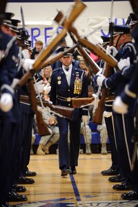 Capt. Michael Fanton, U.S. Air Force Honor Guard Drill Team commander, walks through a 'gauntlet' of spinning M-1 Garand rifles with fixed bayonets during a 16-man drill team performance displaying Air Force precision and professionalism during a performance for the Ro-Hawks of Randolph High School during an assembly Nov. 2. (U.S. Air Force photo/Steve Thurow)