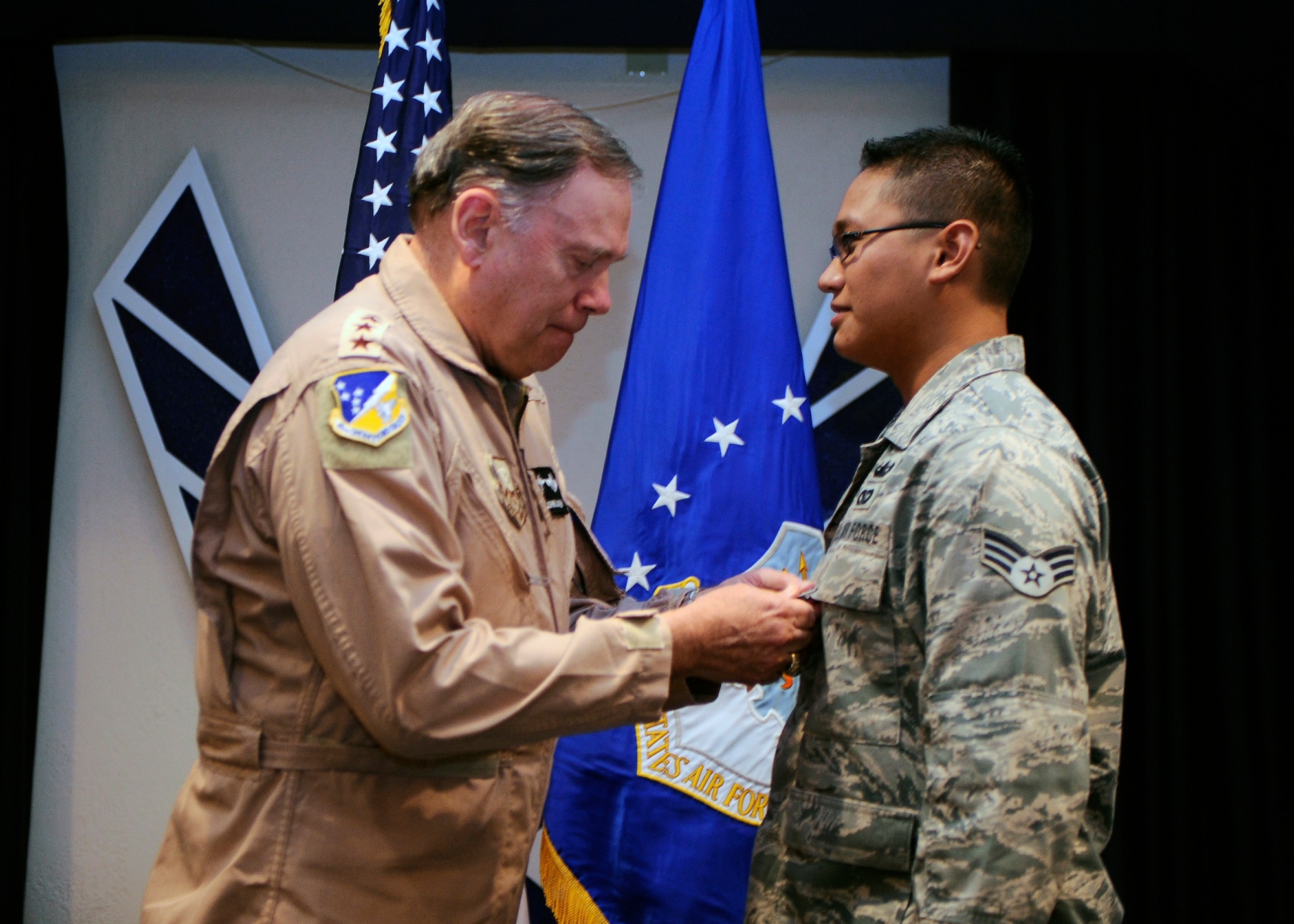 HOLLOMAN AIR FORCE BASE, N.M. -- Gen. John Jumper, retired Chief of Staff of the Air Force, presents Senior Airman Bren Mejia, 49th Civil Engineer Squadron, with a Purple Heart and Bronze Star with Valor during a Warrior Call here, Oct. 30. Airman Mejia was recognized for his heroic actions during a recent deployment to Afghanistan. (U.S. Air Force photo by Airman 1st Class Veronica Stamps)
