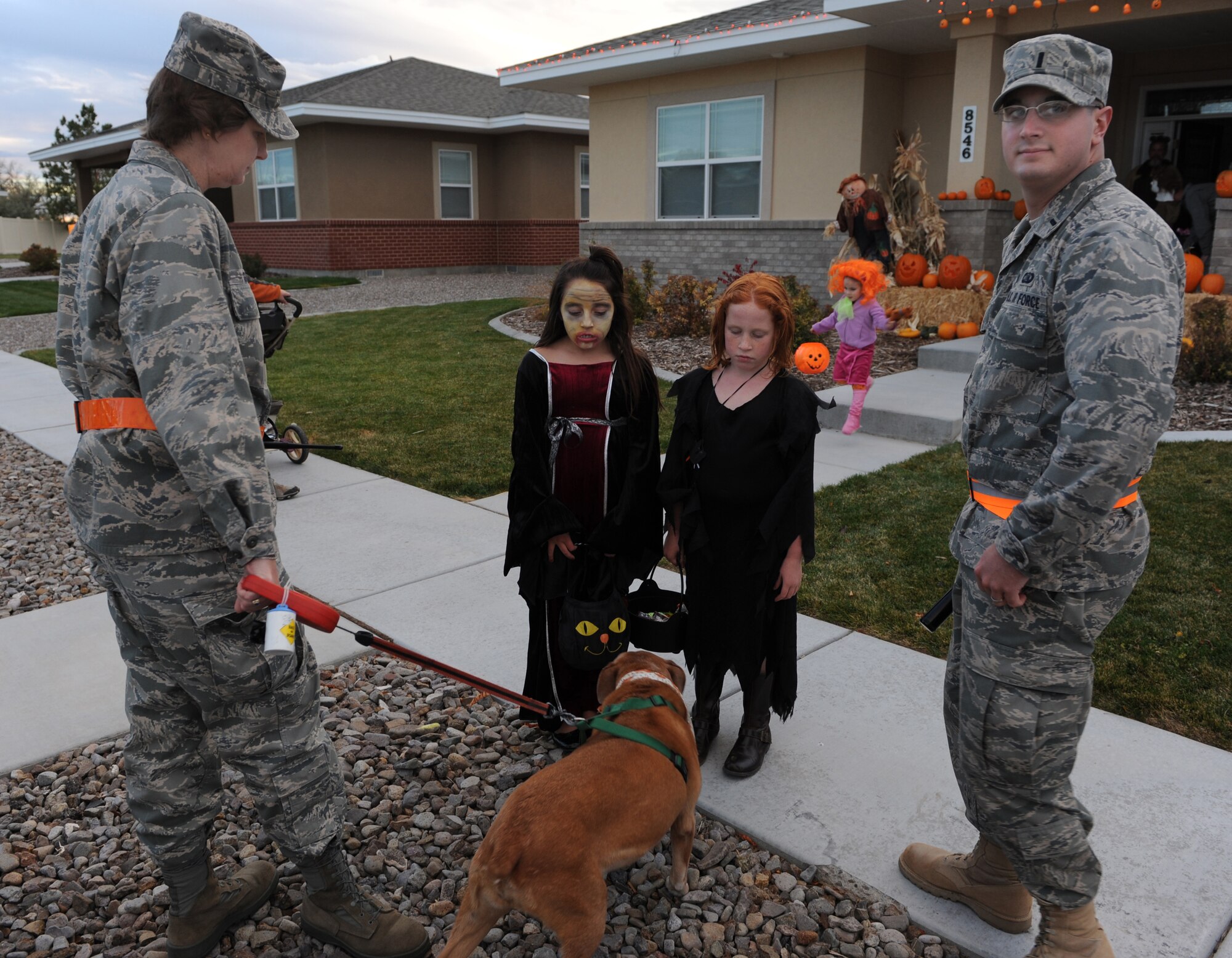 MOUNTAIN HOME AIR FORCE BASE, Idaho -- Lt. Col. Cynthia Gaare and 1st Lt. Christopher Higgins, both pumpkin patrol volunteers, watch as children trick-or-treat in base housing Oct. 31. The 366th Security Forces Squadron conducts a pumpkin patrol on base each year to ensure the safety of children and their families as they trick-or-treat and celebrate Halloween. (U.S. Air Force photo by Airman 1st Class Debbie Lockhart)