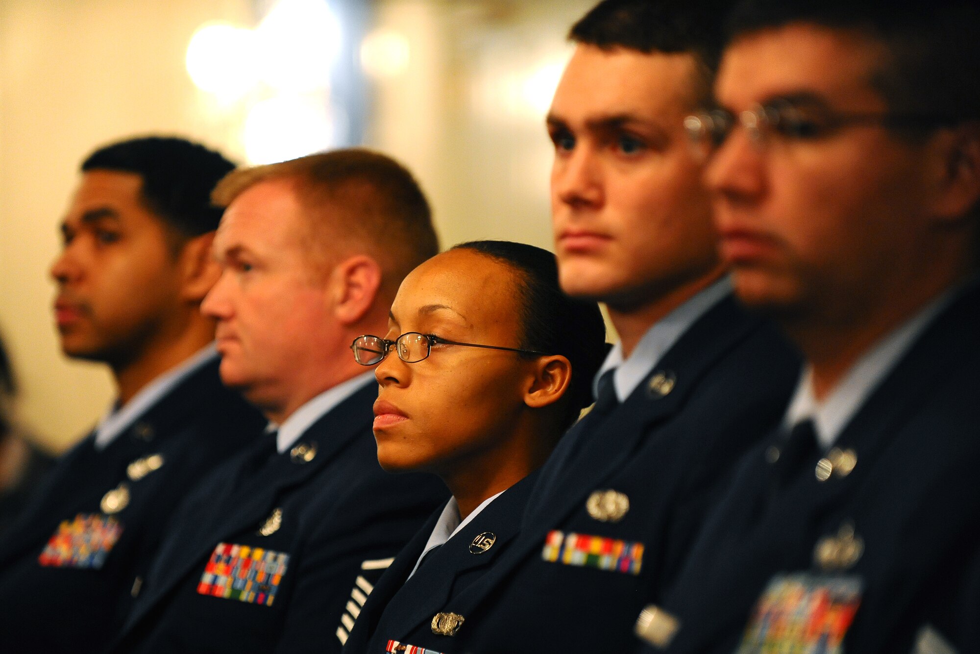 OFFUTT AIR FORCE BASE, Neb. - Senior Airman Brittney A. Simpson, 55th Security Forces Squadron, and several other Community College of the Air Force graduates, listen to the event's keynote speaker Chief Master Sgt. Gary B. Carter, superintendent for the 1st Weather Group for the Air Force Weather Agency, during a ceremony at the Patriot Club here  Oct. 30. Airman Simpson was on of 47 Airmen who received their CCAF degrees during the ceremony. U.S. Air Force Photo by Josh Plueger