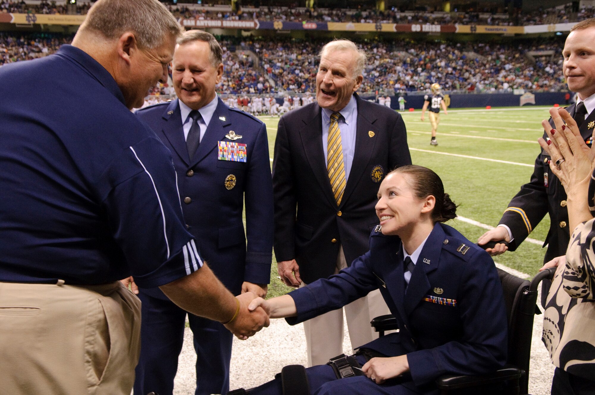 University of Notre Dame head football coach Charlie Weis greets Capt. Wendy Kosek, a member of the JAG corp currently undergoing physical therapy at Brook Army medical Center for wounds sustained in Iraq, during a ceremony honoring alumni at half-time of the Notre Dame, Washington State football game held at the Alamo Dome in San Antonio, Texas. (U.S. Air Force by Steve Thurow)