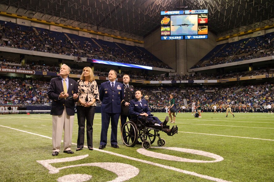 Chuck Lennon, Notre Dame Alumni Association executive director; Holly Colman Notre Dame alumni association president; Maj. Gen. Fred Roggero Air Force chief of safety; Army Capt. Joe Kosek, assistant professor of Army Science for the Notre Dame Army ROTC program; and Capt. Wendy Kosek, a 19th Airlift Wing legal officer currently undergoing physical therapy at Brook Army medical Center for wounds sustained in Iraq, watch a video outlining the general's contributions to the Air Force during a ceremony honoring alumni at half-time of the Notre Dame, Washington State football game held at the Alamo Dome in San Antonio, Texas. (U.S. Air Force photo/Steve Thurow)