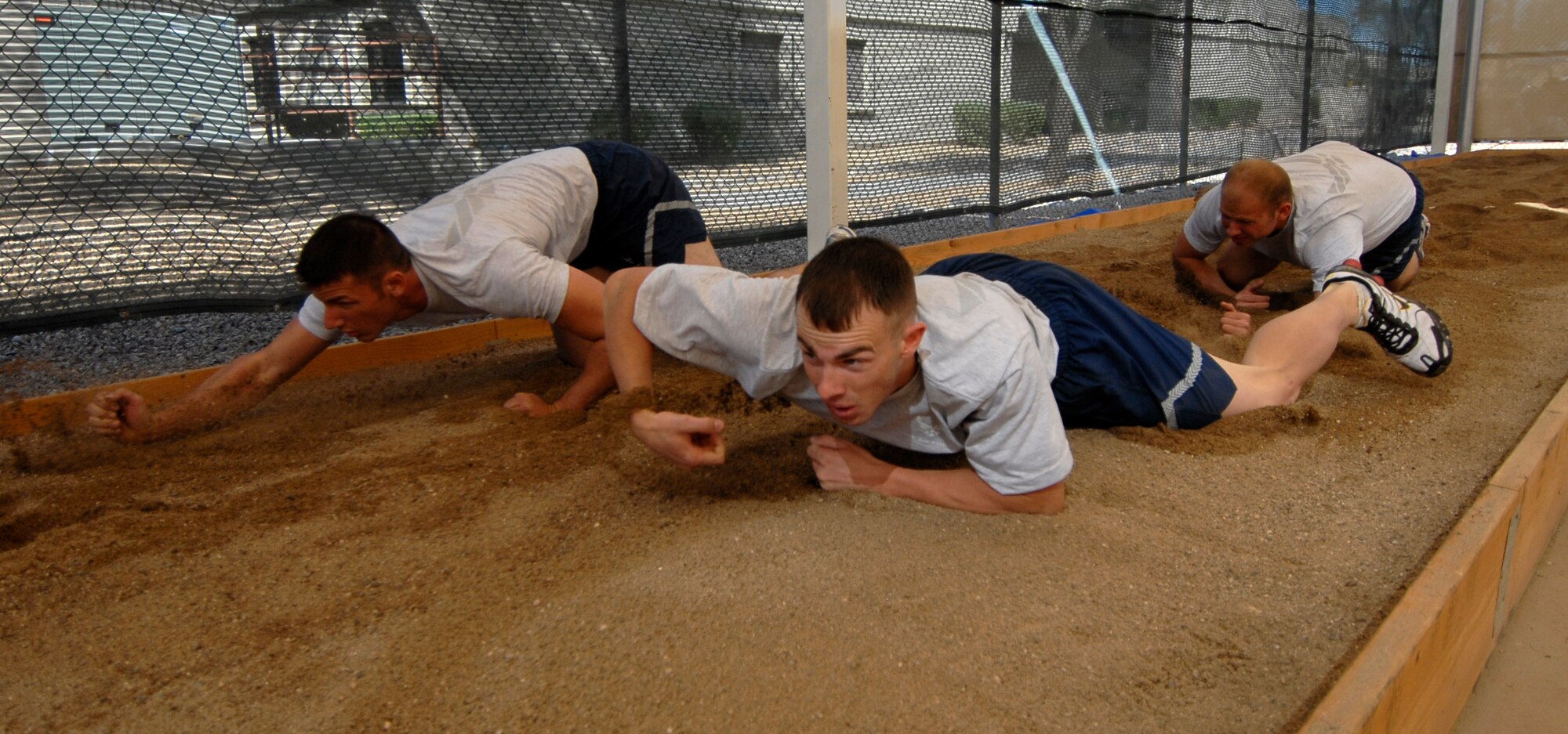 Members of the 56th Security Forces Squadron low-crawl in the newly-minted Combat PT Course on Luke Air Force Base, Ariz.  (U.S. Air Force photo by Tech. Sgt. Jeffrey A. Wolfe)