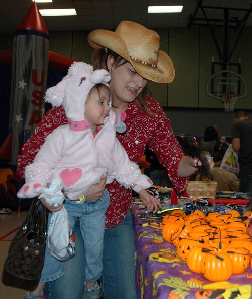 Kat Pickrell and 2-year-old Kylee look over the gift table at the Youth Center's Fall Festival Oct. 30. (U.S. Air Force photo/Senior Airman Dillon White)