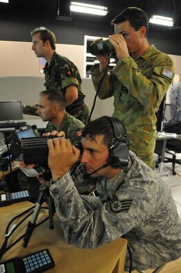 KIRTLAND AIR FORCE BASE, N.M. -- Joint Terminal Attack Controllers from Australia, Canada, the United Kingdom and the United States work on the Joint Close Air Support simulator during the ground-breaking Coalition Virtual Flag exercise at the Distributed Mission Operations Center on Sept. 24. The exercise brought the four coalition forces together for the first time in a large-scale virtual exercise simulating elements in a Theater Air Control System. Twenty-five remote locations participated in the warfighter exercise. From the back are Flight Lieutenant Matt Jupp, 601 TACP, United Kingdom; Warrant Officer Darcy Cyr, Canadian Forces Army JTAC, Air, Land Integration Cell;  Squadron Leader Harvey Reynolds, Royal Australian Air Force, and Staff Sgt. Andrew Guidry, U.S. Air Force.  (U.S. Air Force photo/Ken Moore)

KIRTLAND AIR FORCE BASE, N.M. -- JTACS from The name of the Aussie JTAC in the photo is Squadron Leader Harvey
Reynolds.
-SSgt Andrew Guidry is the US JTAC full name
