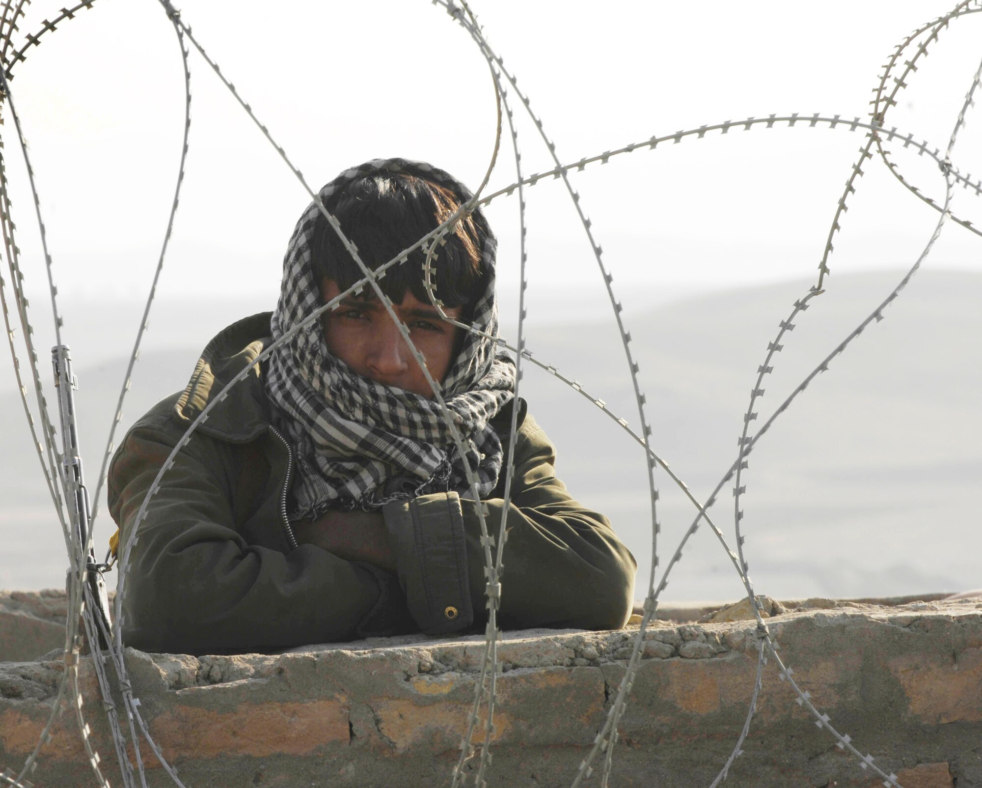 An Afghan guard peers out from behind the walls of a prison Oct. 28, 2009, in Qalat, Afghanistan. Security forces Airmen and American Soldiers met with prison officials Oct. 28, 2009, as part of an on-going mission to better the prison and mentor the guards. (U.S. Air Force photo/Tech. Sgt. Joseph Kapinos) 