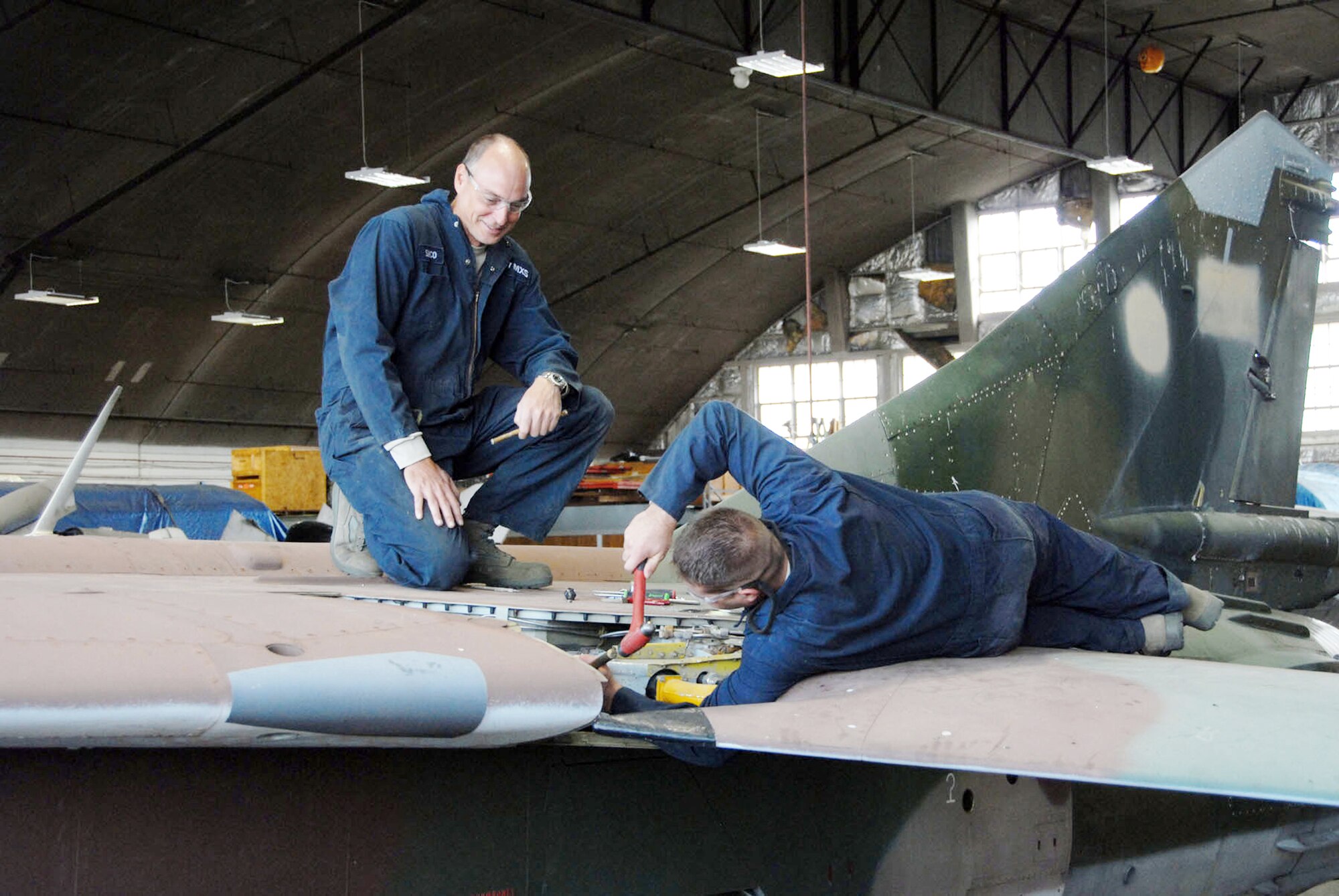 Reservists with the 315th Maintenance Squadron from Charleston Air Force Base, S.C., work to remove a wing from a MiG-23 during their two-week stay at Wright-Patterson Air Force Base, Ohio, where the group worked in the restoration hangar at the National Museum of the U.S. Air Force in nearby Dayton. (U.S. Air Force photo)