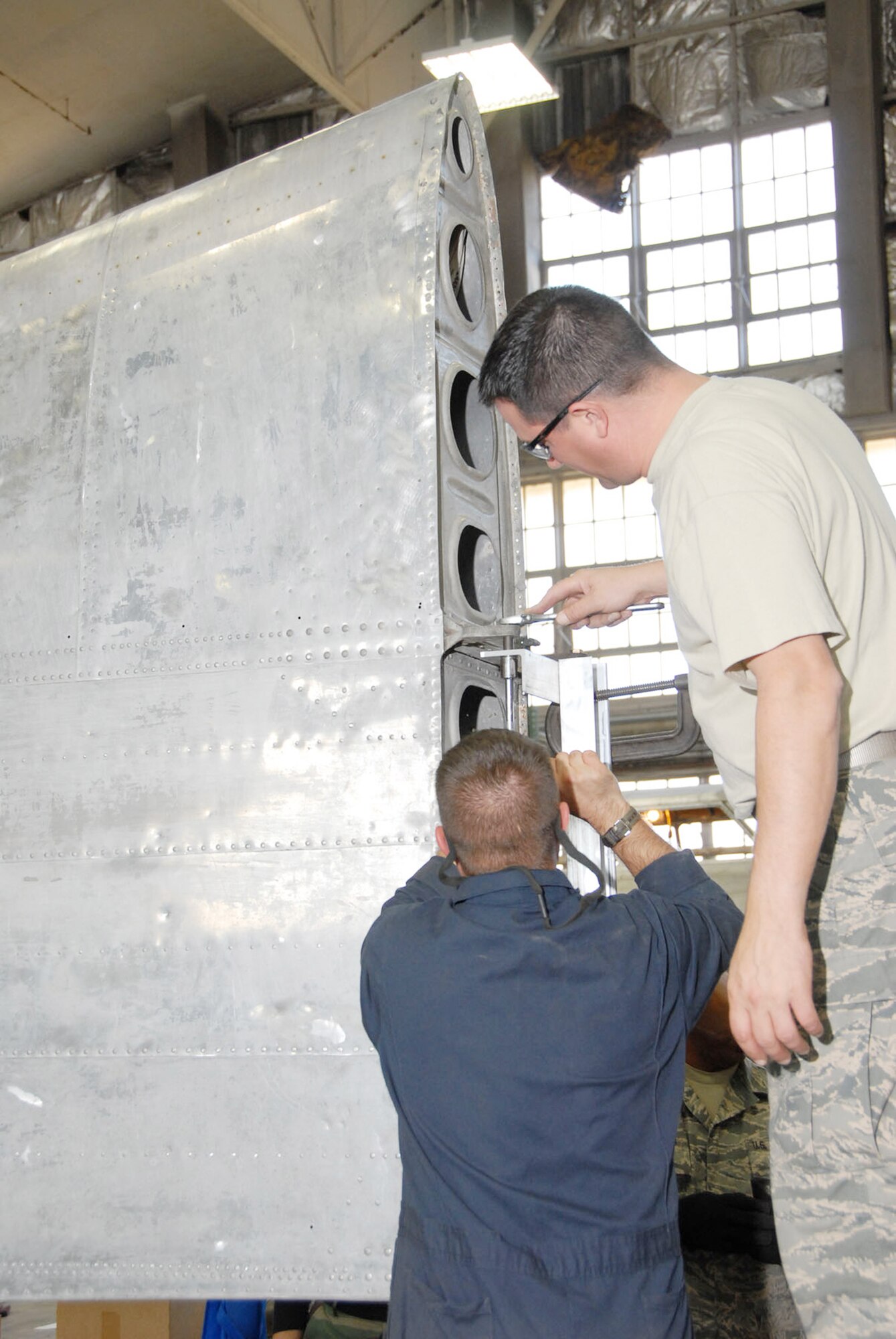Reservists with the 315th Maintenance Squadron from Charleston Air Force Base, S.C., piece together a holding fixture for the B-17 Memphis Belle's wing during their two-week stay at Wright-Patterson Air Force Base, Ohio, where the group worked in the restoration hangar at the National Museum of the U.S. Air Force in nearby Dayton. (U.S. Air Force photo)