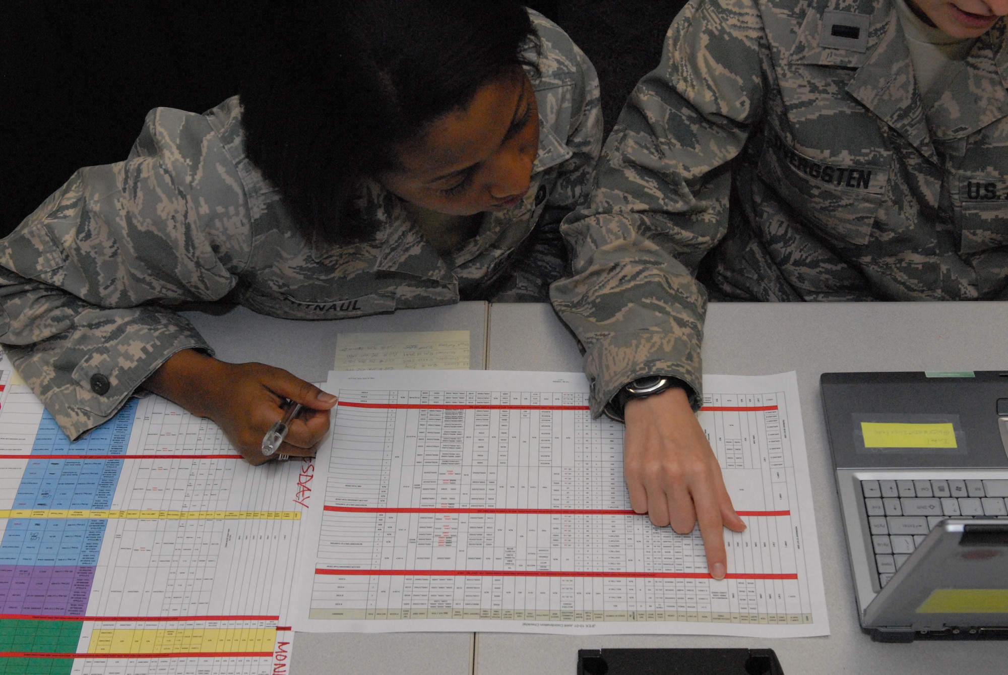 1st Lt. Jocelyn Mitnaul, Deputy Chief of Intel for the 437th Airlift Wing at Charleston Air Force Base, S.C., watches as 1st Lt. Jill Dvergsten, 50th Airlift Squadron Chief of Intel from Little Rock AFB (right), points out the evening’s flying schedule Oct. 28 as part of a joint force exercise at Pope AFB, NC. The JFEX focused on cohesive training between the Air Force and Army to reestablish forcible entry capability through air power. (U.S. Air Force photo by Senior Airman Nathan Allen)
