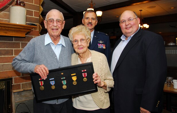 Sixty Four years after he left the service, Mr. Morstad and his wife hold a shadow box filled with medals he earned during four years of service during World War II at a small ceremony in Fond Du Lac, Wis., Nov 1.  Corporal Morstad enlisted in the Army Air Corps in June of 1941 and served overseas as a radio operator and air traffic controller until the end of the war in 1945. Mr. Morstad and his wife stand with Colonel Gunther Neumann, director of operations for the Wisconsin Air National Guard and Mr. Dave Anderson, district director for Wisconsin Congressmen Tom Petri. (U.S. Air Force photo by Master Sgt. Dan Richardson)