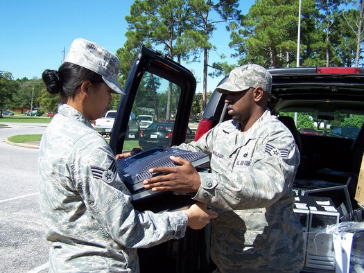 FORT WALTON BEACH, Fla. - Senior Airman Grace Blazado and Staff Sgt. Terrance Walker, both from the 505 Communications Squadron, 505th Command and Control Wing, unpack computers members of the squadron prepared to donate to Max Bruner Junior Middle School. The Airmen, who also volunteered to work on the computers on weekends, set up four of the nine computers in the school's study room. (U.S. Air Force photo by Noel Getlin)